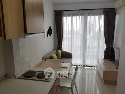 Modern compact living room with kitchenette and large window, perfect for urban living.