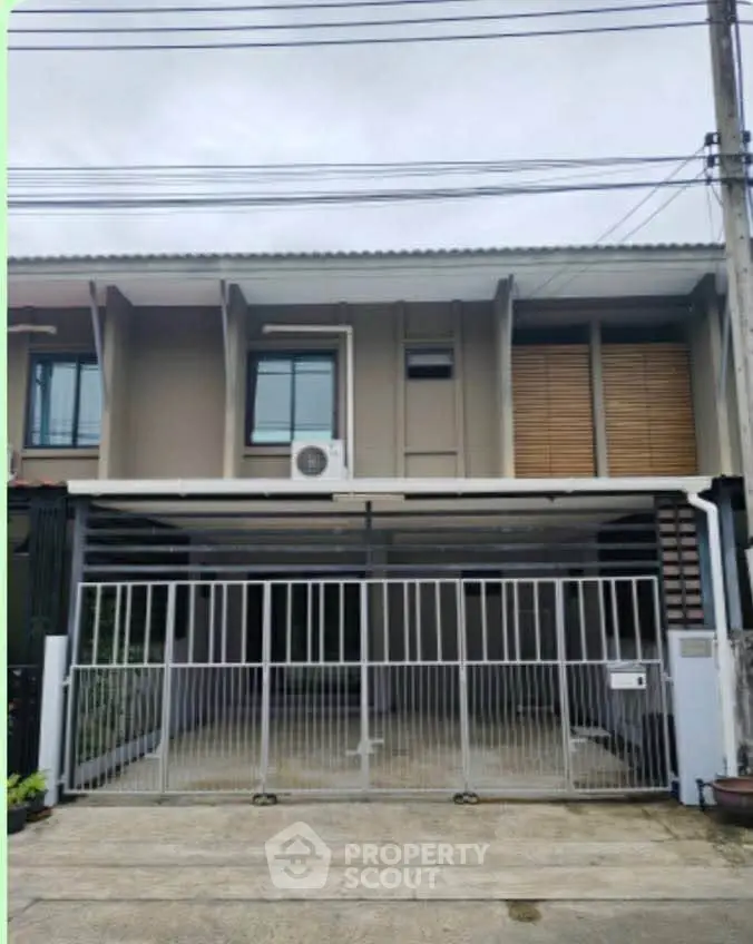 Modern townhouse exterior with gated entrance and contemporary design.