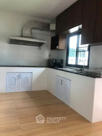 Spacious kitchen with modern cabinetry and ample natural light