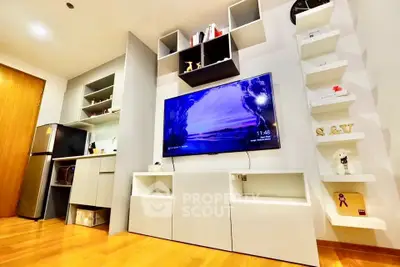 Modern living room with sleek shelving and mounted TV in stylish apartment.
