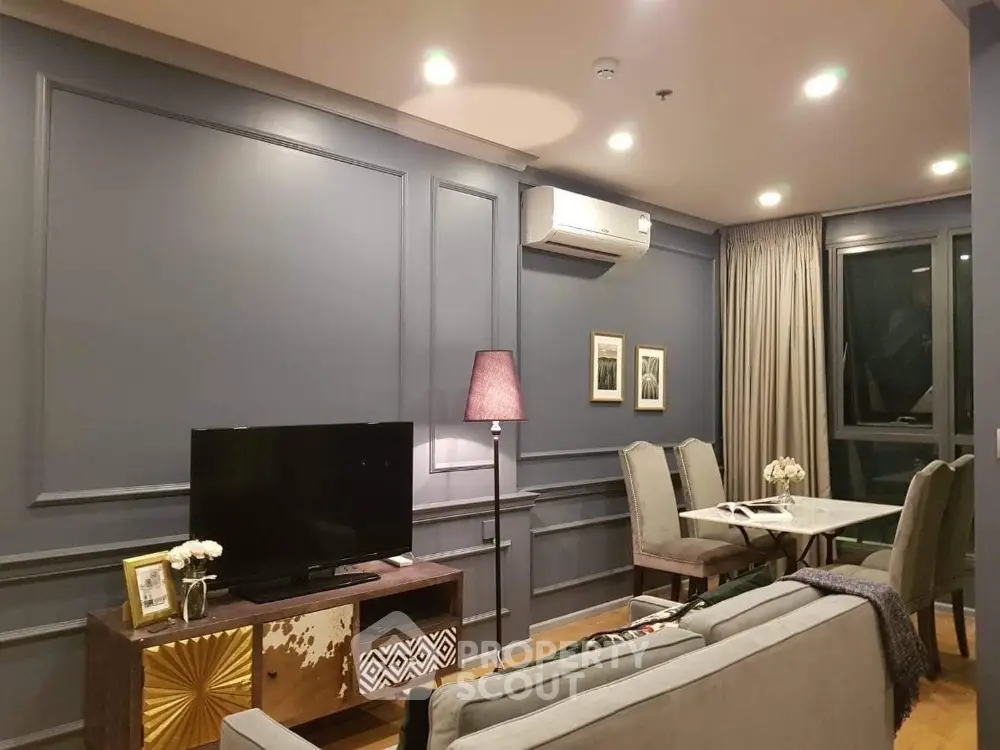 Elegant living room with modern decor and dining area, featuring ambient lighting and stylish furnishings.