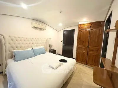 Luxurious bedroom with elegant furnishings and ambient lighting, featuring a plush bed and wooden wardrobe.