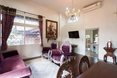 Elegant living room with vintage furniture and chandelier, featuring a cozy ambiance.