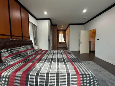 Spacious modern bedroom with stylish decor and ample natural light.