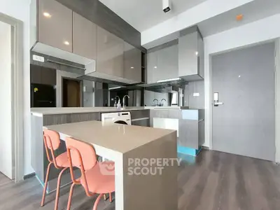 Modern kitchen with sleek cabinetry and stylish dining area in a contemporary apartment.