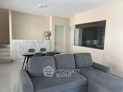 Spacious living room with modern gray sofa and elegant dining area