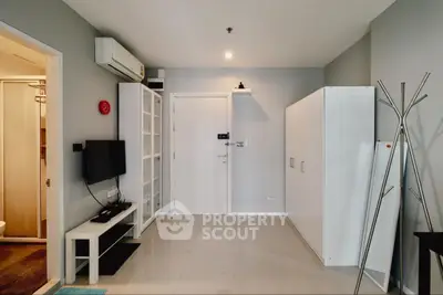 Modern living room with sleek furniture and minimalist design, featuring a wall-mounted TV and ample storage.