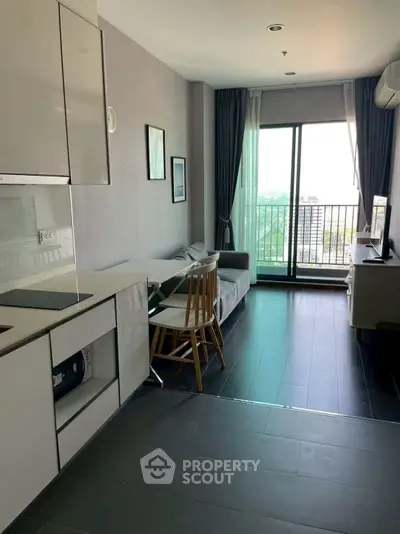 Modern apartment with open kitchen and balcony view, featuring sleek design and natural light.