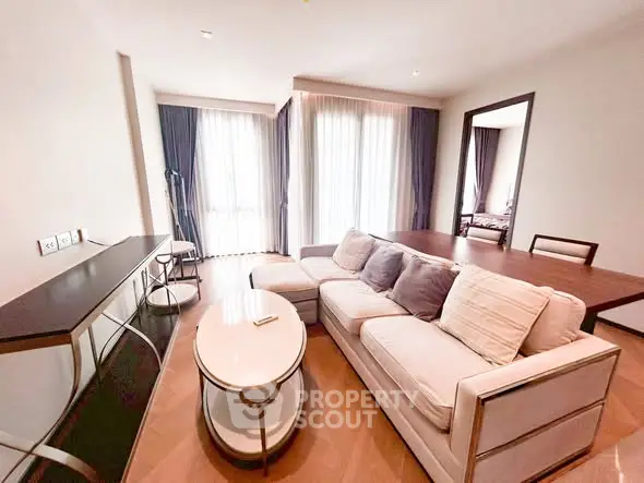 Spacious living room with modern furniture and natural light in a stylish apartment.