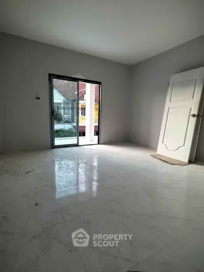 Spacious unfurnished room with large window and glossy floor tiles, ideal for customization.