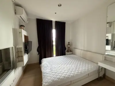 Cozy bedroom with modern decor, featuring a comfortable bed, wall-mounted TV, and air conditioning.