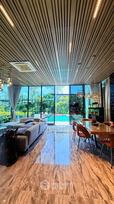 Luxurious open-plan living room with pool view, modern decor, and elegant lighting.