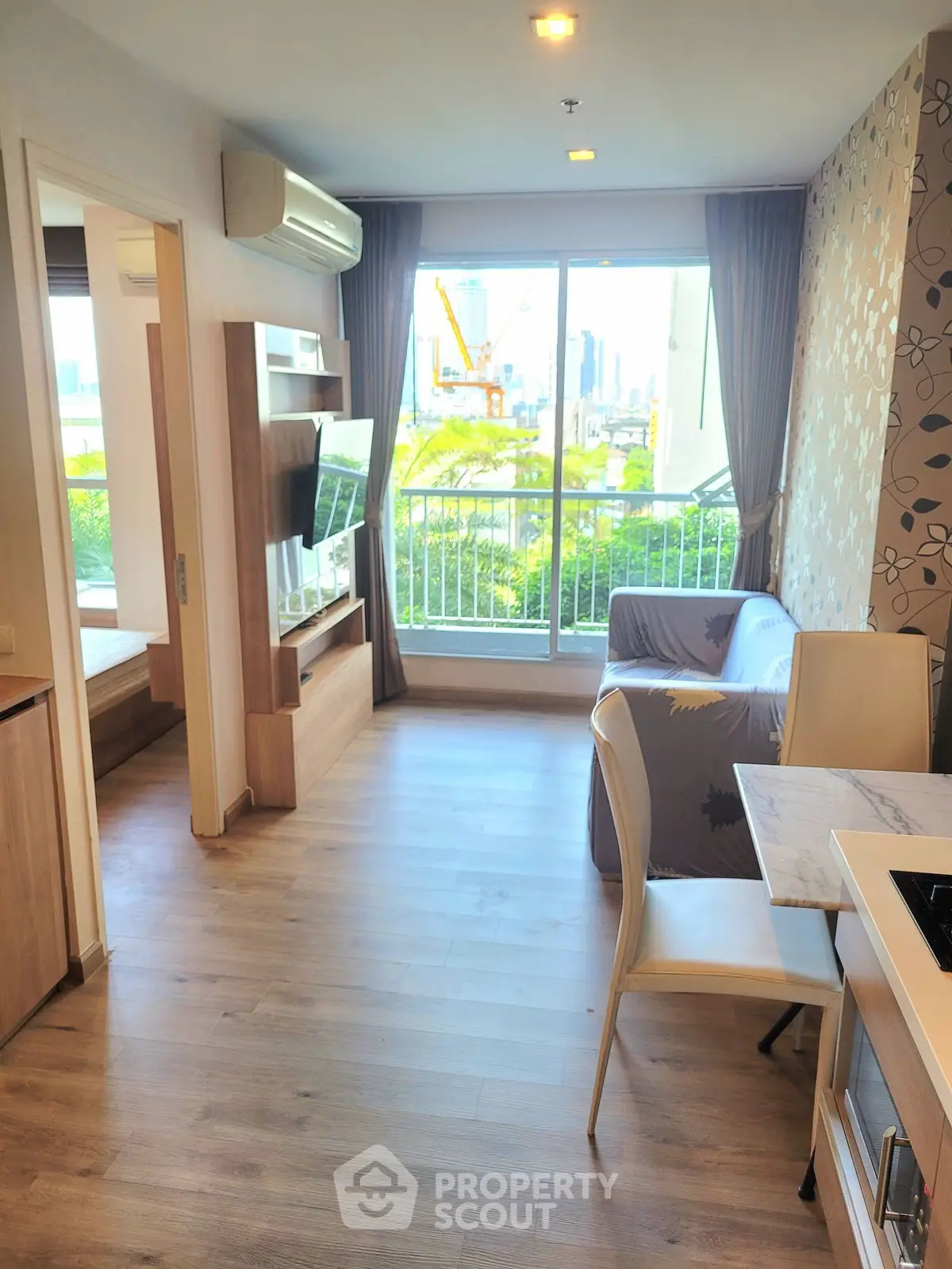 Modern living room with open layout and city view, featuring stylish decor and natural light.