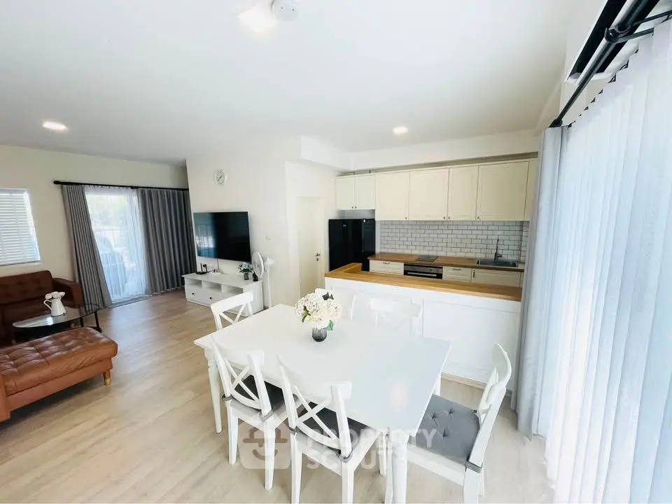 Bright open-plan living room with modern kitchen and elegant dining area, perfect for family gatherings.