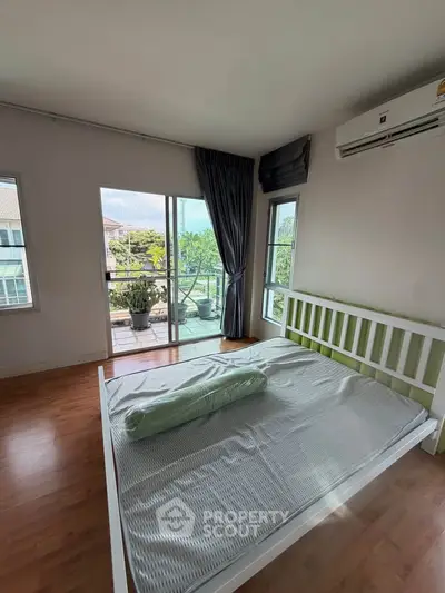 Spacious bedroom with balcony access and natural light in modern apartment