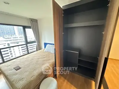 Modern bedroom with large window and spacious wardrobe in urban apartment