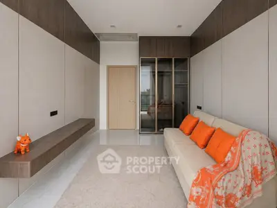 Modern living room with stylish decor and vibrant orange accents