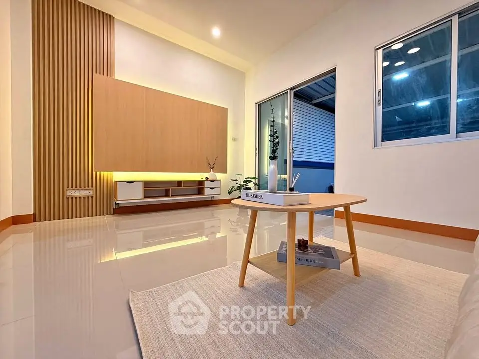 Modern living room with sleek design and cozy ambiance, featuring stylish furniture and ambient lighting.