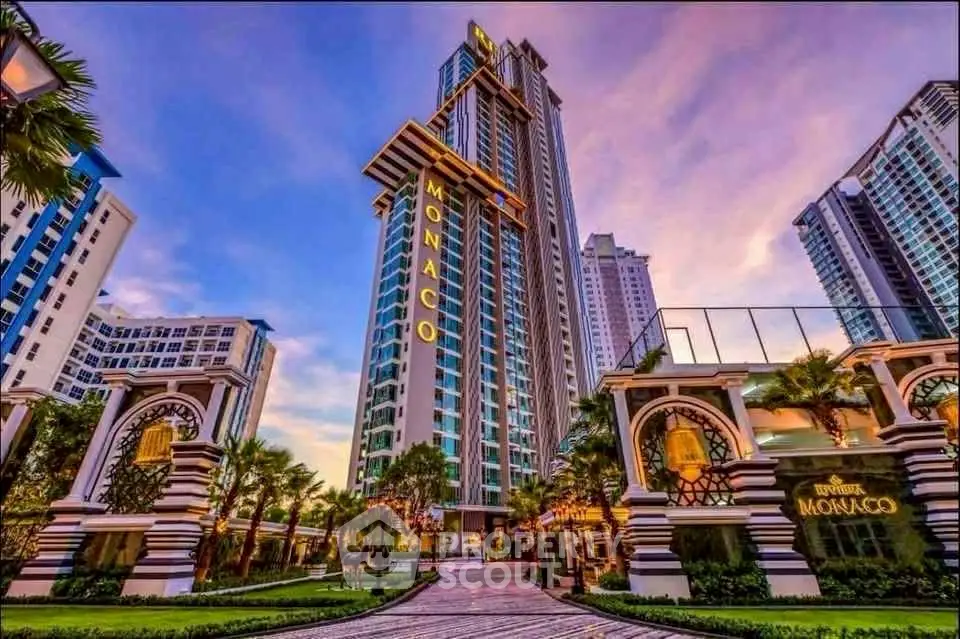 Stunning high-rise building with luxurious entrance and vibrant sunset sky.