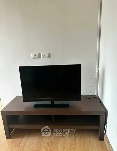 Modern living room with sleek TV setup on wooden stand, perfect for cozy entertainment.