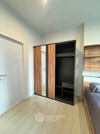 Modern bedroom with sleek wooden wardrobe and minimalist design