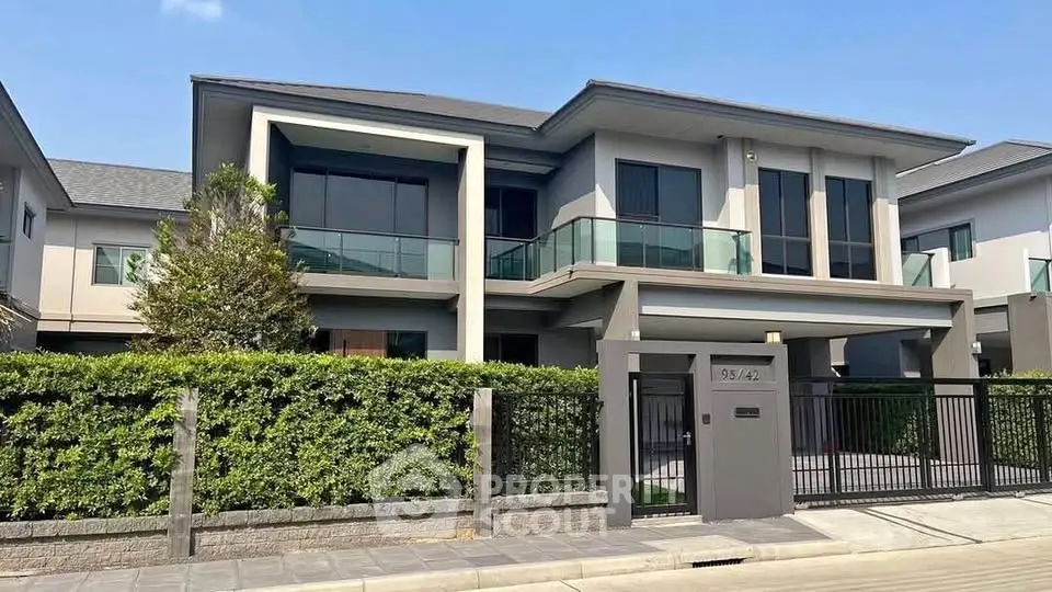 Modern two-story house with sleek design and spacious balcony in a serene neighborhood.