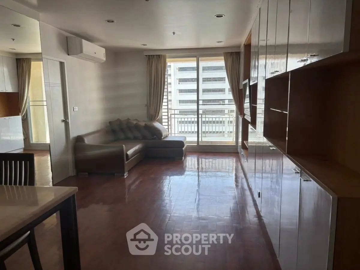 Spacious living room with modern furniture and large windows offering city views.