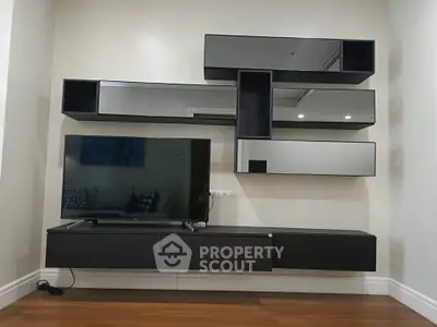 Modern living room with sleek wall-mounted TV and stylish shelving unit.