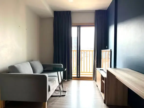 Modern living room with balcony access and stylish furniture in a bright apartment.