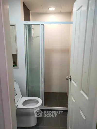 Modern bathroom with glass shower enclosure and sleek toilet design.