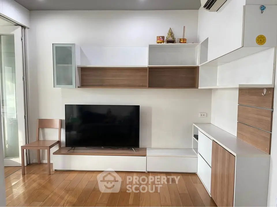 Modern living room with sleek wooden flooring and stylish TV unit