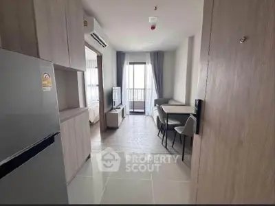 Modern apartment interior with open layout, featuring a cozy living area and dining space near a balcony.