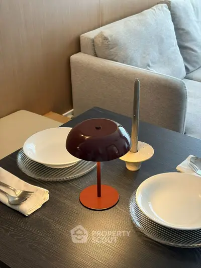 Modern dining setup with stylish lamp and cozy sofa in elegant living room.