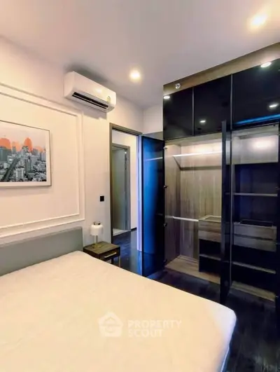 Modern bedroom with sleek wardrobe and air conditioning in stylish apartment.