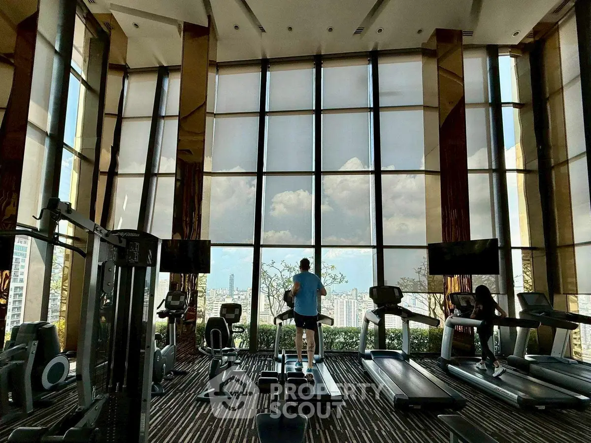 Luxurious high-rise gym with panoramic city views and modern fitness equipment.