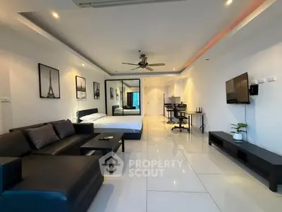 Spacious modern living room with sleek black furniture and elegant decor in open layout apartment.