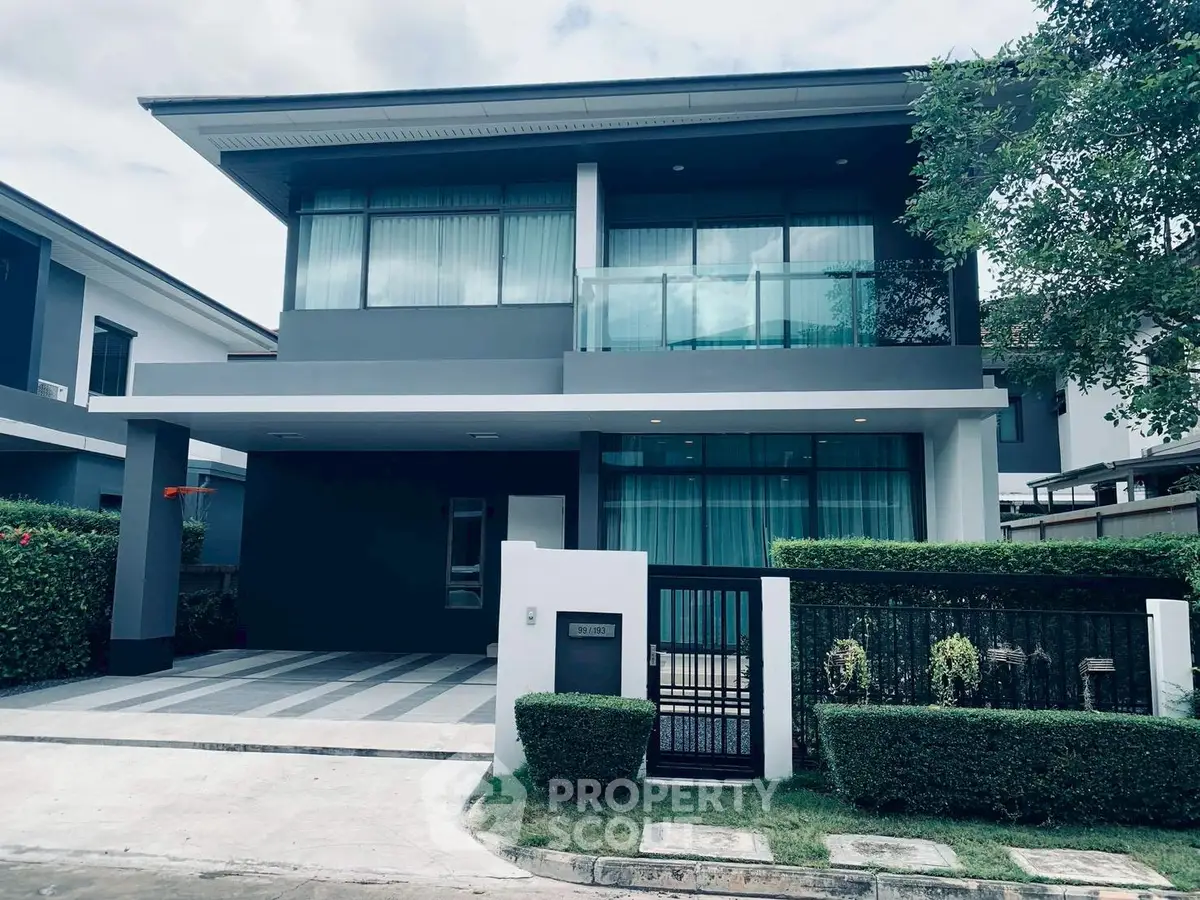 Modern two-story house with sleek design and large windows in a suburban neighborhood.