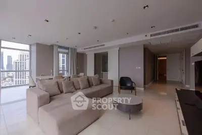Spacious modern living room with city view and elegant furnishings in a high-rise apartment.