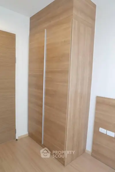 Modern wooden wardrobe in a minimalist bedroom with sleek design