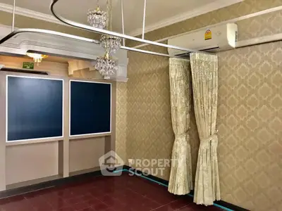 Elegant room with chandeliers and air conditioning, featuring luxurious curtains and patterned wallpaper.