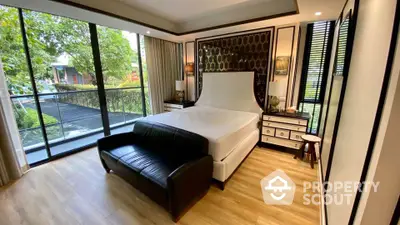 Luxurious bedroom with large windows and elegant decor, featuring a stylish bed and a cozy seating area.