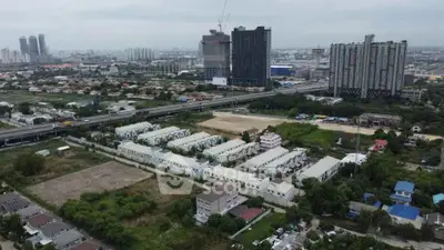 Aerial view of urban residential area with high-rise buildings and highway access.