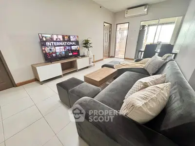 Spacious modern living room with plush sofa and large TV, perfect for relaxation.