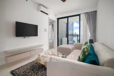 Modern living room with balcony view, stylish furniture, and natural light.