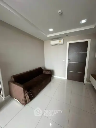 Modern living room with sleek sofa and air conditioning in a minimalist apartment.