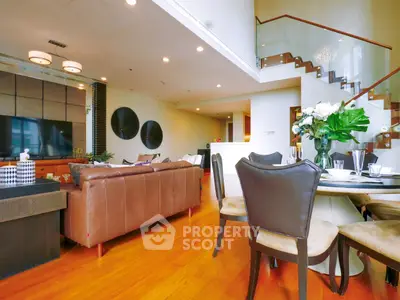 Luxurious open-plan living room with elegant staircase and modern decor