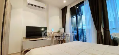 Modern bedroom with city view, featuring sleek furniture and large windows for natural light.