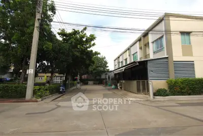 Modern townhouse exterior with lush greenery and spacious driveway in a serene neighborhood.