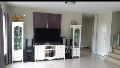 Spacious living room with modern entertainment center and elegant decor.