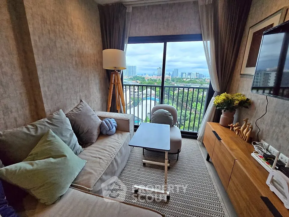 Chic living room with cozy sofa, modern decor, and stunning city view from balcony.